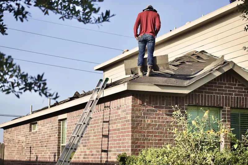 Professional roofer working on a residential roof in Lowell Junction